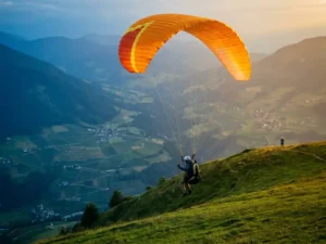 Student paraglider start solo vlucht vanaf Alpiene bergkam bij gouden uurszonlicht, met instructeur op afstand en dal beneden.